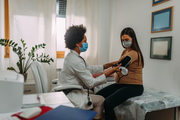 Pregnant woman with PCOS getting her vitals checked at the doctor.